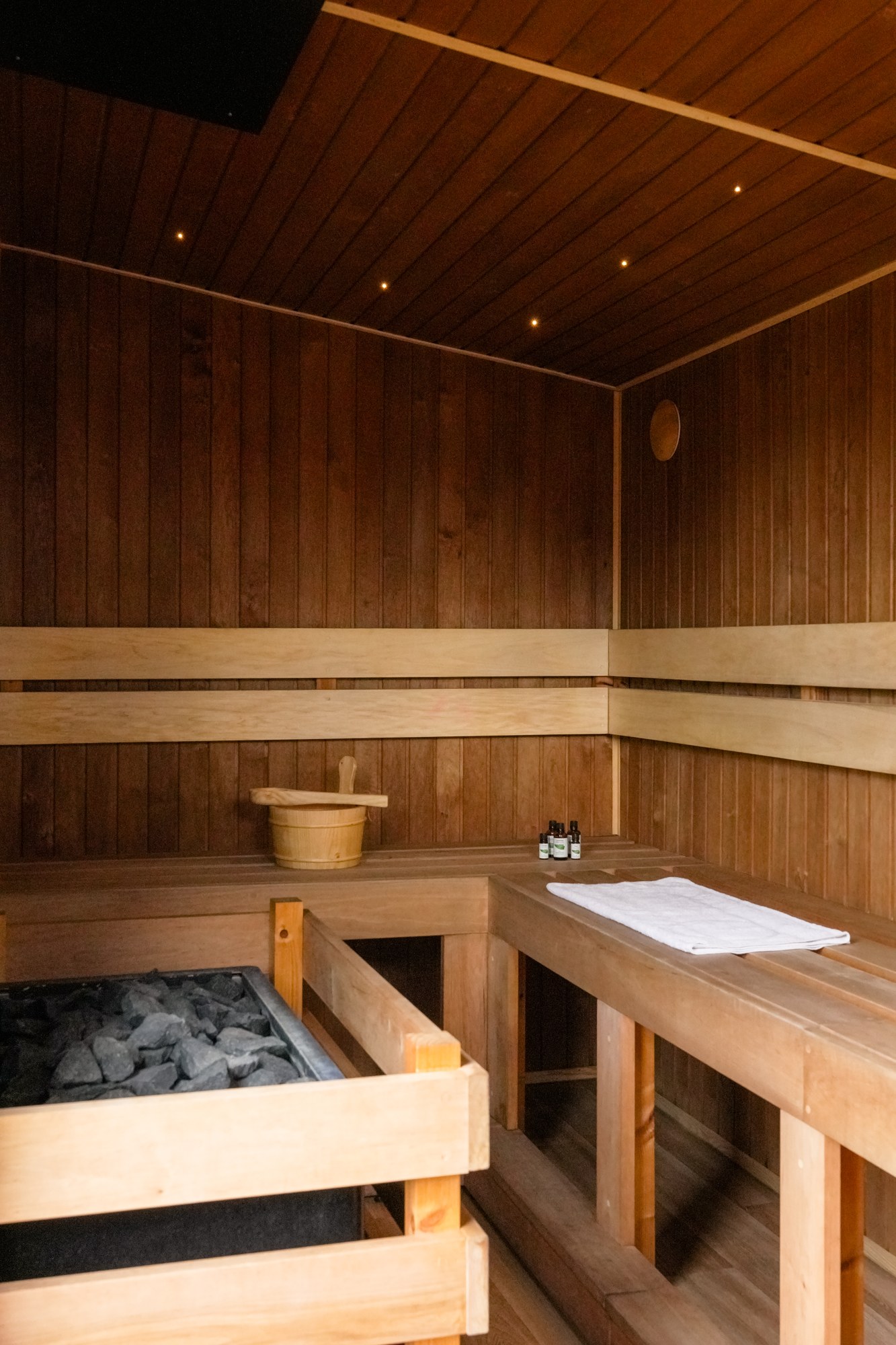 Timber benches and guarded heater in Wild Sauna’s interior